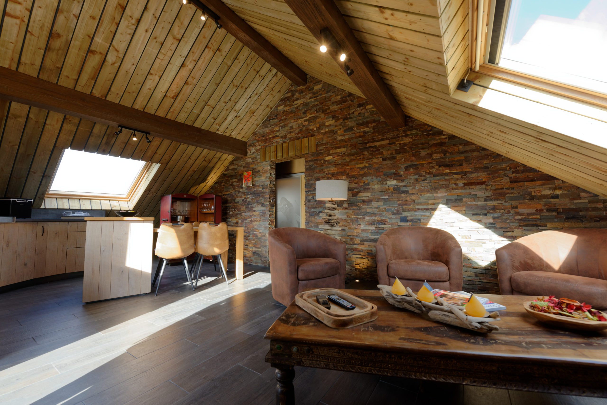 Séjour du gîte avec finitions en bois et en pierre